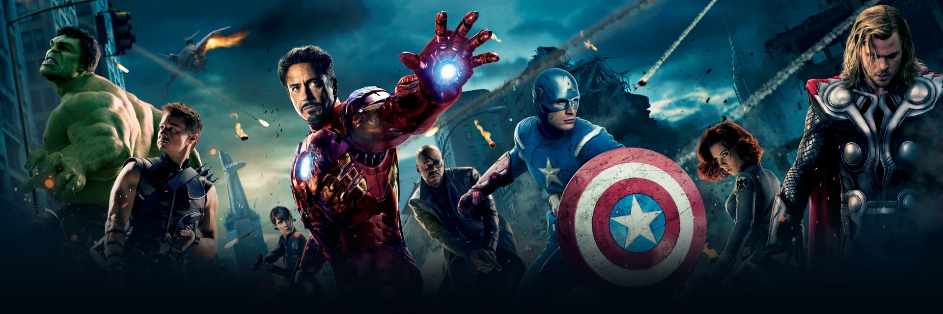 A picture of the Avengers during a battle in their fighting poses with a city in the background.