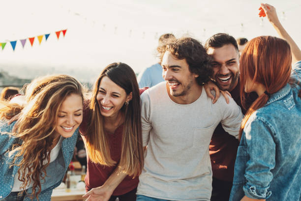 A group of people laughing and having fun at a party outside