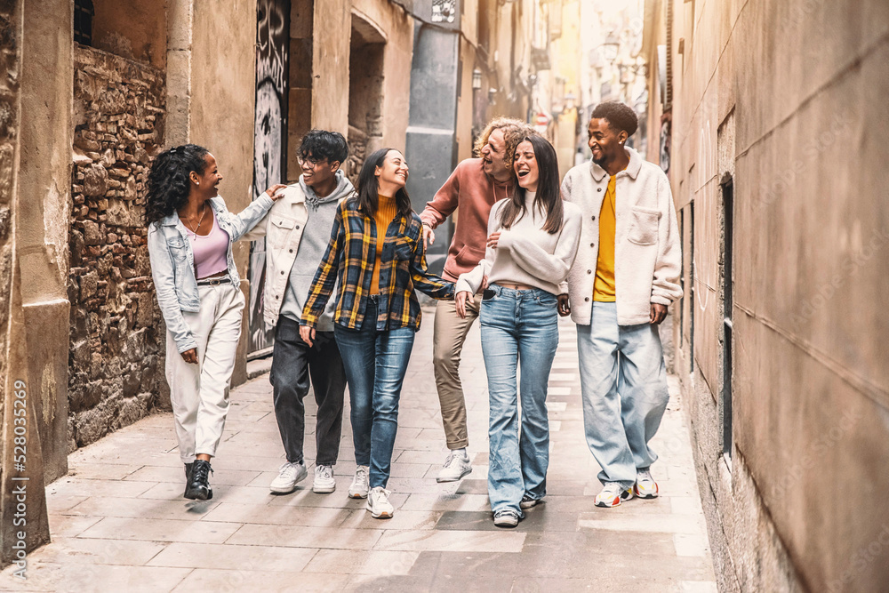 A happy group of people laughing and talking on a street in the city