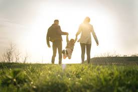 A family holding hands outside in a field